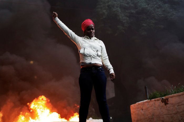 A member of Brazil's Movimento dos Sem-Teto (Roofless Movement) gestures in front of a burning barricade during a protest against President Temer's proposal reform of Brazil's social security system in the general strike in Sao Paulo